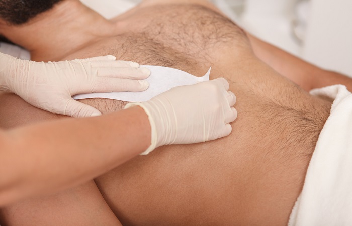 Man getting waxing hair removal at the salon